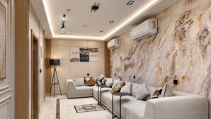 A modern living room with a sectional sofa, a floor lamp, and artwork on the walls. - Zahret Alforsan Hotel (Makkah)