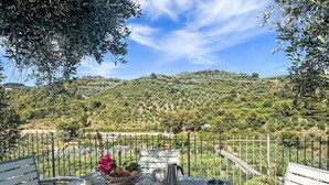 A table set outdoors with a view of a hilly landscape. - Beautiful apartment for 4 people with A/C, WIFI, patio and panoramic view (Finale Ligure)