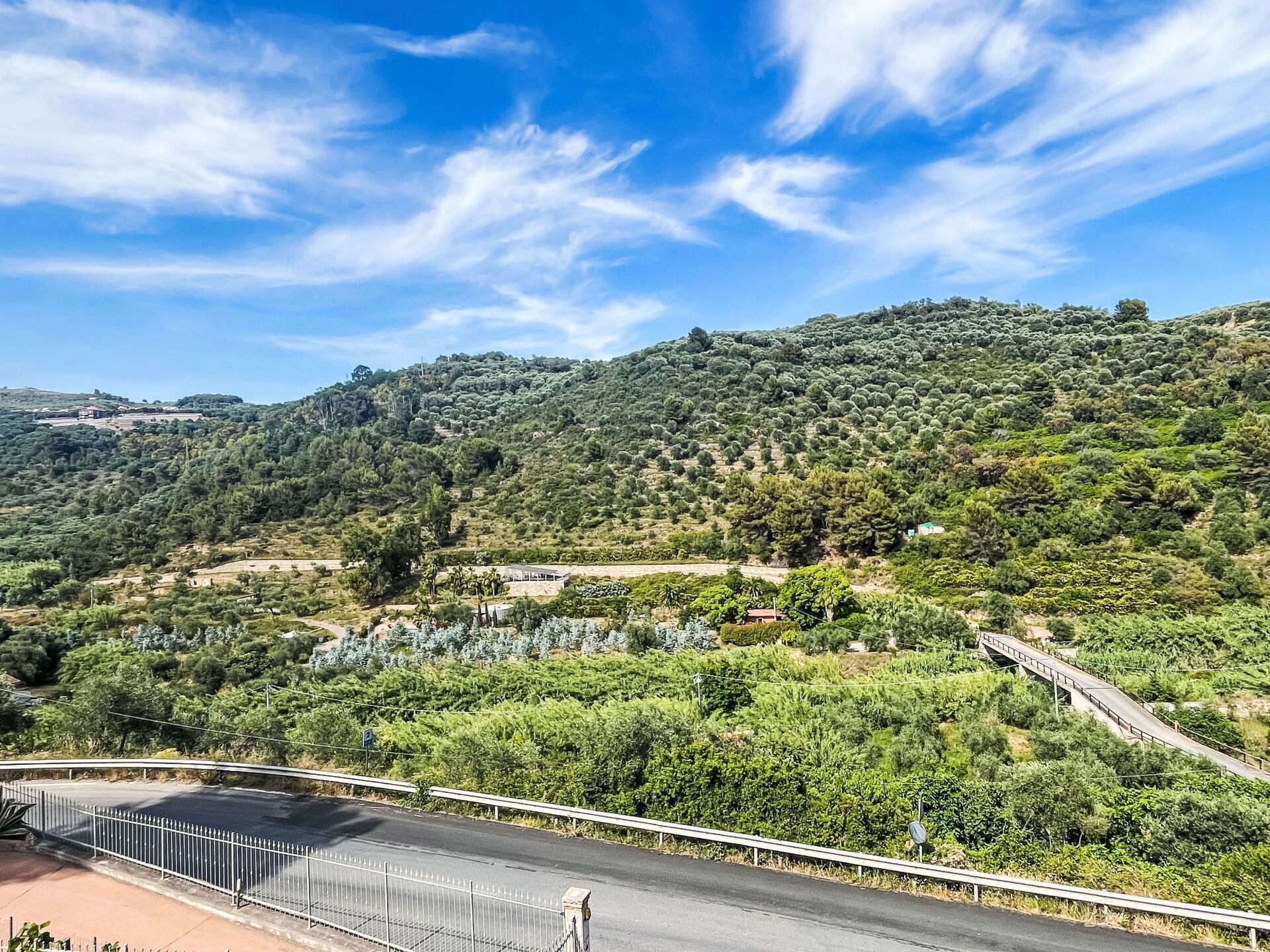 Una vista panorámica de un paisaje montañoso con una carretera y un puente.