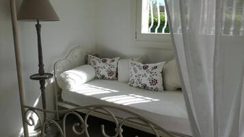 A room with a bed, a lamp, and a window with curtains.