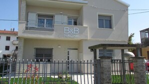Un bâtiment à deux étages sur lequel on peut lire l’inscription « B&B Nadine ».