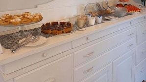 Un buffet de petit-déjeuner proposant une variété de viennoiseries, de fruits et de produits laitiers.