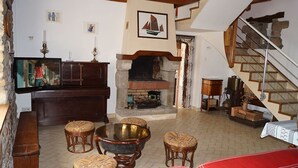 Ein gemütliches Wohnzimmer mit Kamin, einer Holztreppe und einem Fernseher.