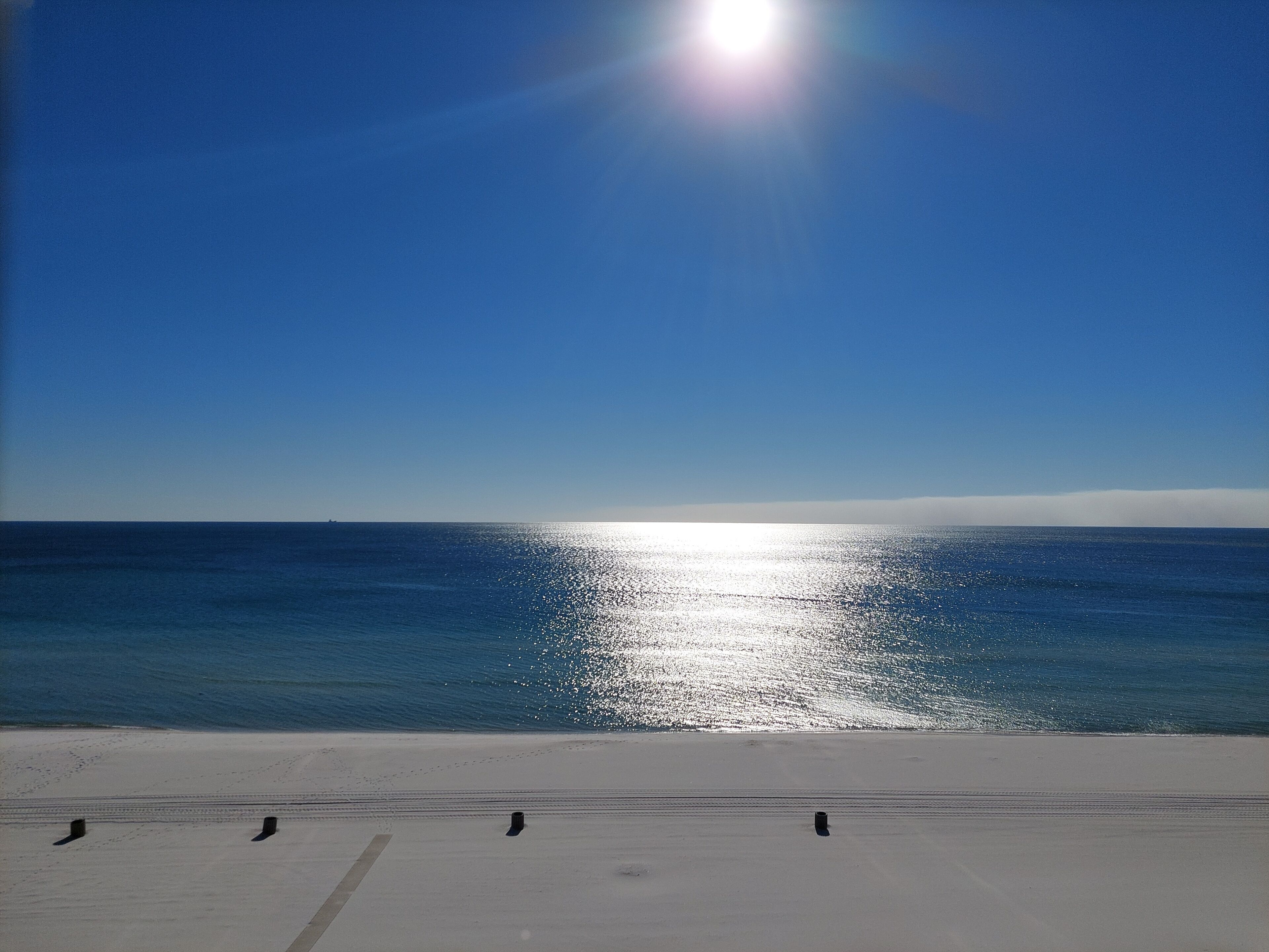 Una playa con cielo despejado y mar tranquilo.
