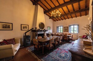 Un comedor con una gran mesa de madera, sillas y una chimenea.