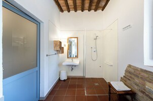 Un bagno con doccia, lavandino e specchio.