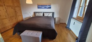 Une chambre à coucher avec un lit, une table de chevet et une fenêtre.
