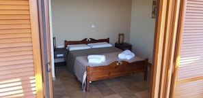 Ein Schlafzimmer mit einem hölzernen Bett, einem Nachttisch und einem Beistelltisch.