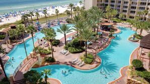 A resort with a large pool area, palm trees, and a beach. - Looking for a Shore Thing? Here it is! 2BR 2.5ba Sleeps 8! Beachfront! (Panama City Beach)