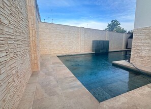 Ein Schwimmbecken mit Steinwänden und gefliestem Boden.