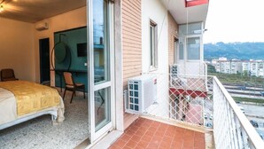 Ein Balkon mit einem Bett, einem Schreibtisch und einem Stuhl.