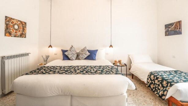 Ein Hotelzimmer mit einem großen Bett, zwei Nachttischen, einer Heizung und Bildern an den Wänden.