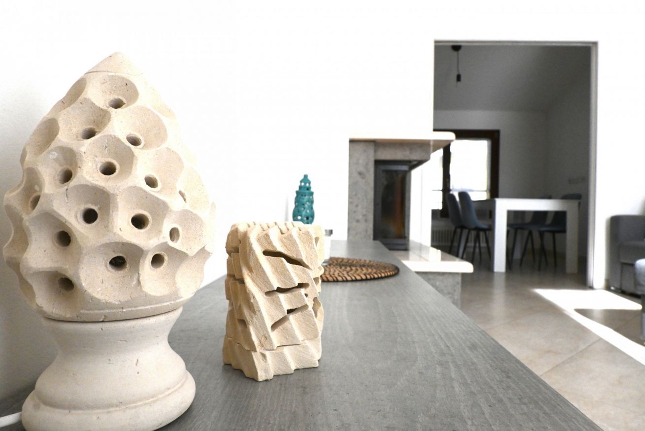 Un interior moderno con comedor, chimenea y dos esculturas únicas.