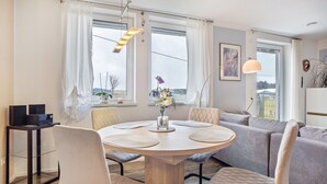 Ein Essbereich mit rundem Tisch, Stühlen und einer Couch.