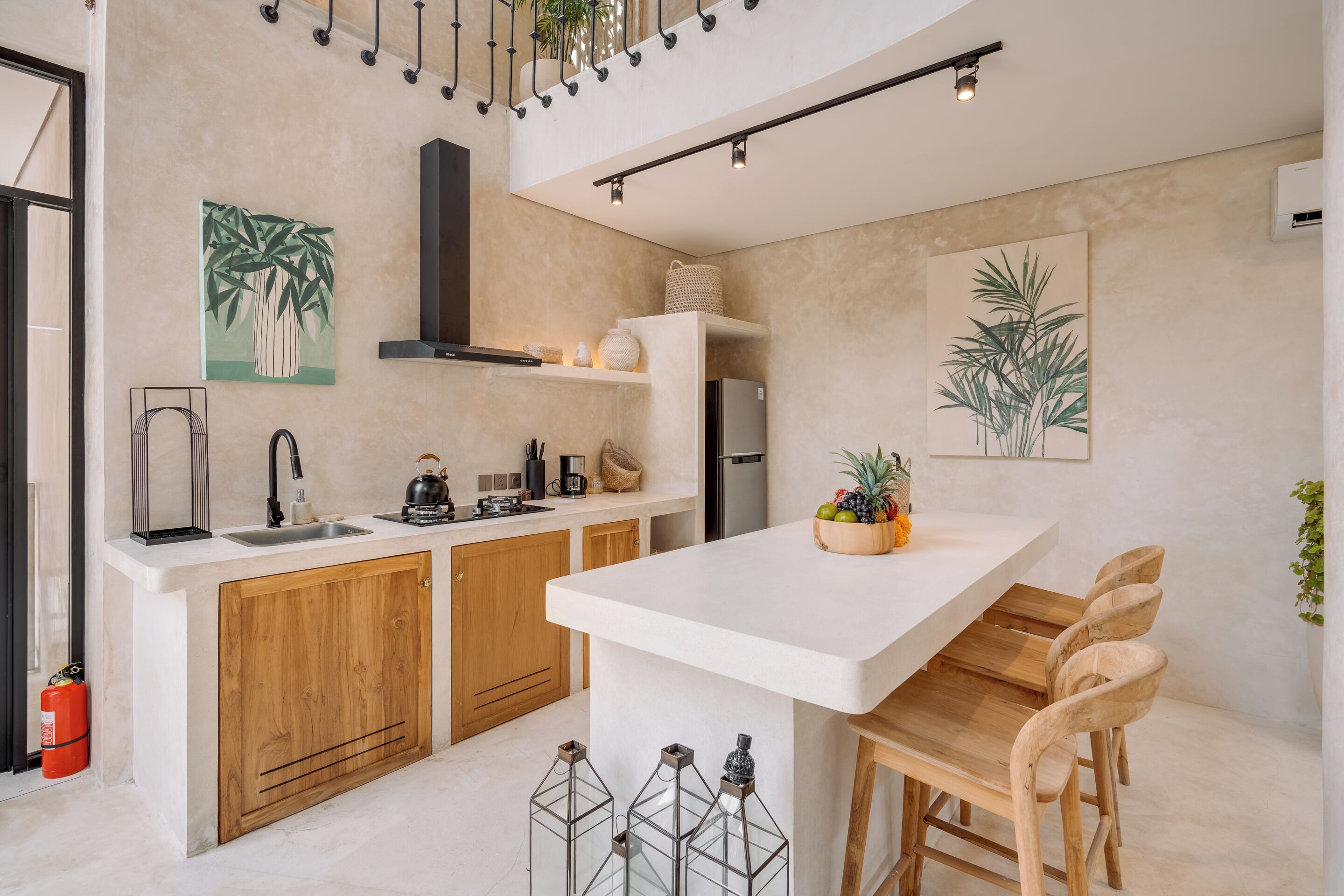 Una cucina moderna con mobili in legno, un piano di lavoro bianco e una penisola centrale con sgabelli da bar.