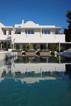 A modern white building with a swimming pool in front. - Santorini Heart Hotel & Spa (Santorini)