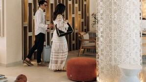 Un interior moderno con mostrador de recepción, un pilar blanco decorativo y muebles contemporáneos.