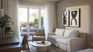 Un salón con sofá, sillón, mesa de centro y vistas al exterior.