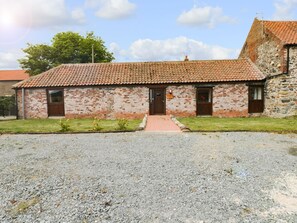 A small brick building with a tiled roof, a gravel driveway, and a grassy area in front. - Meadow View (Hull)
