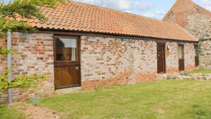 A brick building with a tiled roof, a wooden door, and a window. - Meadow View (Hull)