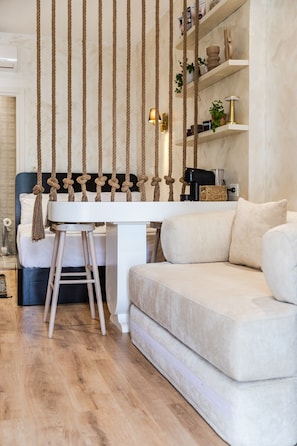 A modern living room with a white sofa, a wooden coffee table, and a hanging rope decoration.
