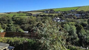 Un paisaje rural con casas, campos verdes y un cielo azul despejado.