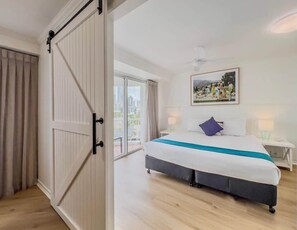 A bedroom with a large bed, a sliding door, a balcony, and a city view. - Renovated Sovereign Surfers Paradise Beachfront (Surfers Paradise)