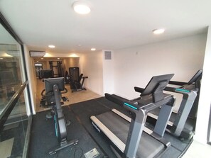 Ein Fitnessstudio mit Laufbändern, Ergometer und Krafttrainingsgeräten.
