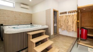 A modern bathroom with a hot tub, wooden steps, a sauna, and a clothing rack. - Villa Ana With Outdoor Pool, Sauna and Hot-tub (Kastela)