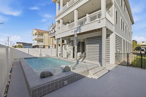 A two-story building with a swimming pool, outdoor seating, and a covered patio area. - For Whom The Beach Tolls: New Coastal Retreat w/ Pool & Stunning Views (Murrells Inlet)