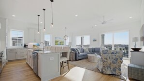 Un amplio espacio de estar con cocina, comedor y un ventanal que ofrece vistas.