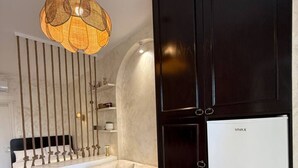 Ein moderner Raum mit einer Couch, einem Esstisch, einer Hängelampe und einem Kleiderschrank mit einer Whiteboard-Fläche.
