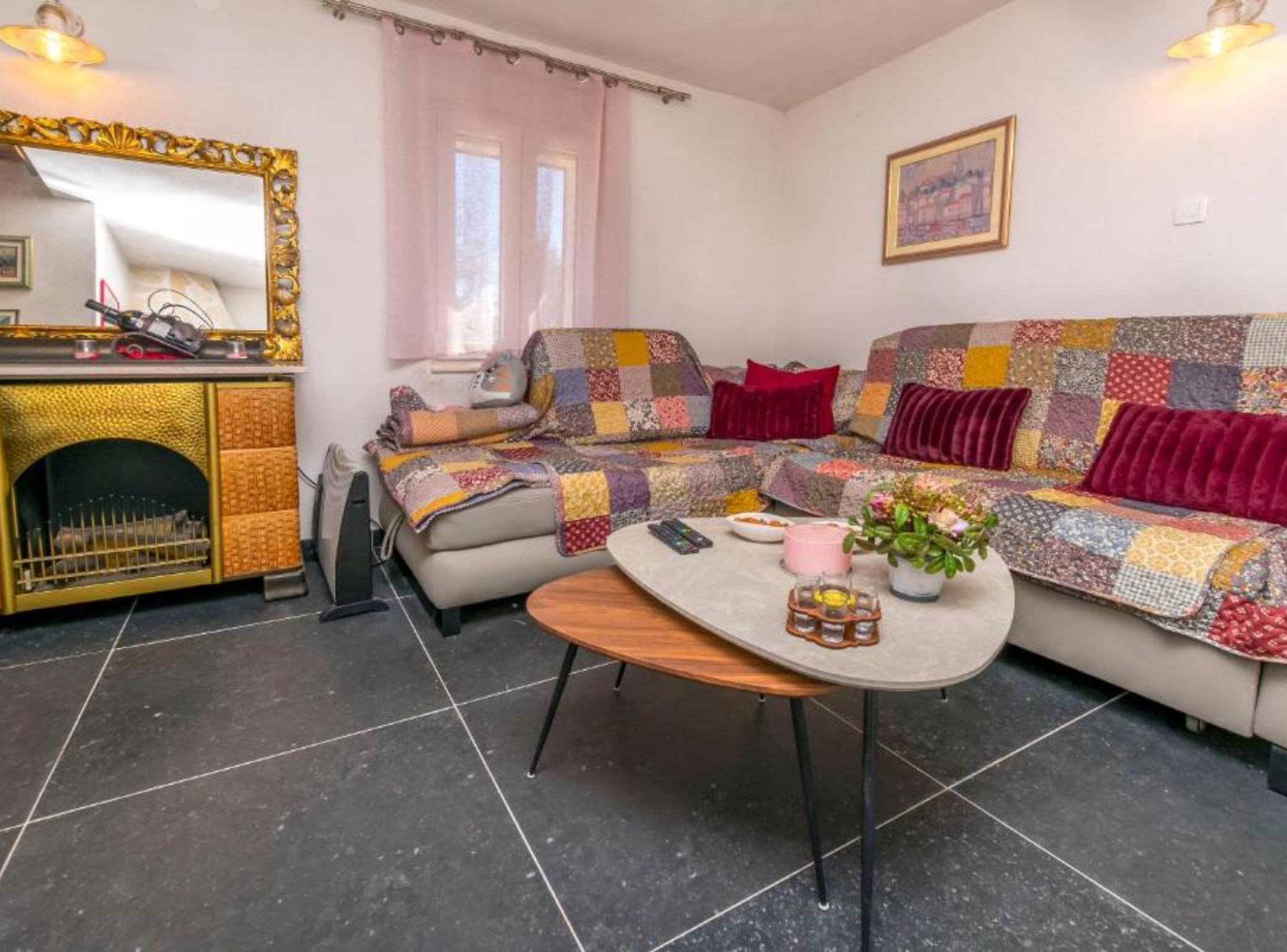 Un salon chaleureux avec un canapé, une table basse, une cheminée et un tableau accroché au mur.