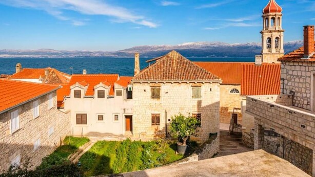 A coastal town with stone buildings, a bell tower, and a view of the sea. - Sutivan Sea Terrace Apartment (Sutivan)