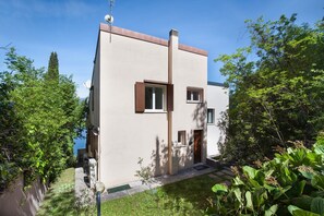 Ein modernes, zweistöckiges Gebäude mit Flachdach, Schornstein und Satellitenschüssel.