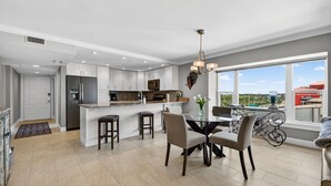 Una cocina moderna con comedor, ventanas amplias y balcón.