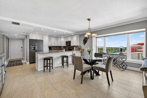 Una cocina moderna con comedor, ventanas amplias y balcón.