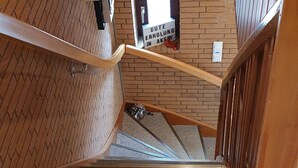 Eine Treppe mit Holzwurf und Backsteinwand, mit Fliesenboden.