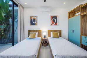 A hotel room with two beds, a wooden wardrobe, and a large window with a view of greenery. - High Tide Hideaway (Playa Hermosa)