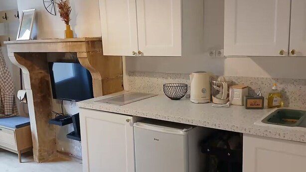A compact kitchen with white cabinets, a small refrigerator, a coffee maker, and a sink. - Modern studio with private garden - Cure thermale Saint-Honoré-les-Bains (Saint-Honoré-les-Bains)