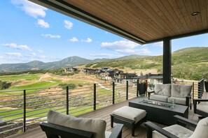 A balcony with outdoor furniture, a view of a golf course, and multiple buildings in the background. - Spacious Ski Getaway Hot Tub 5 Bedroom 5 Home (Heber City)