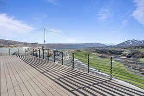 A wooden deck with metal railings overlooking a construction site and a mountainous landscape. - Spacious Ski Getaway Hot Tub 5 Bedroom 5 Home (Heber City)