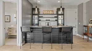 Una cucina moderna con zona bar, con un cartello che riporta 'ALICE B GREENTOWN NY'.