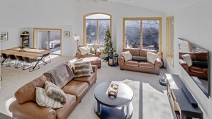 Ein geräumiger Wohnbereich mit großem Fenster, einem Esstisch und Ledersofas.