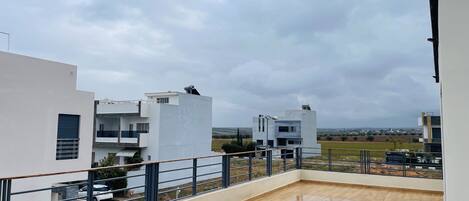 Un edificio moderno con techo plano y balcón de piso de madera.