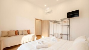 Habitación de hotel con dos camas, un armario y un espejo.