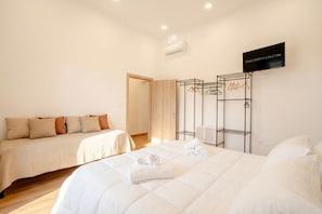 Une chambre d’hôtel avec deux lits, une armoire et un miroir.