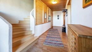 A wooden staircase leading to a landing with a striped rug and a wooden bench. - Apartment 'Gassner' with Balcony and Wi-Fi (Fridolfing)