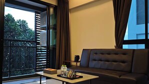 A modern living room with a sofa, a coffee table, and a window with blinds. - ATOUR Rayong Hotel (Pluak Daeng)