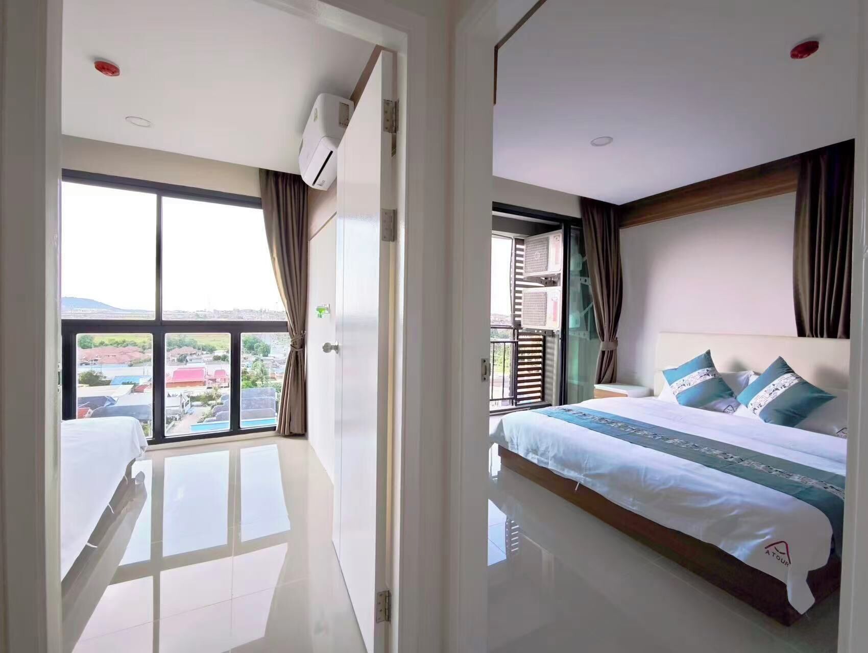 Una habitación de hotel con cama, ventana y vista, y un equipo de aire acondicionado.